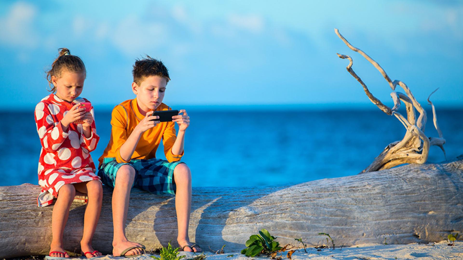 giovani utilizzano smartphone spiaggia