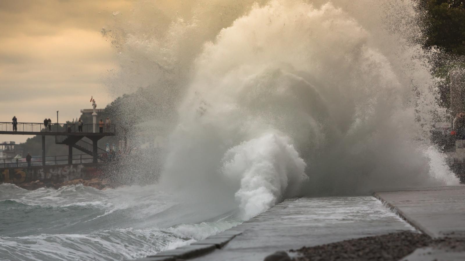 Immagine di un'onda che s'infrange sul molo